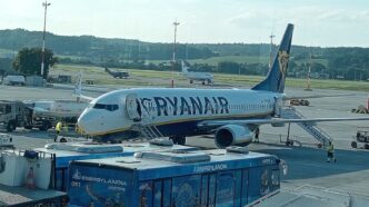 Літак Boeing 737 у ліврі Ryanair біля телетрапа на пероні аеропорту Краків-Балиці, поруч перонний автобус і наземний персонал, денне світло