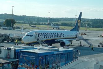 Літак Boeing 737 у ліврі Ryanair біля телетрапа на пероні аеропорту Краків-Балиці, поруч перонний автобус і наземний персонал, денне світло